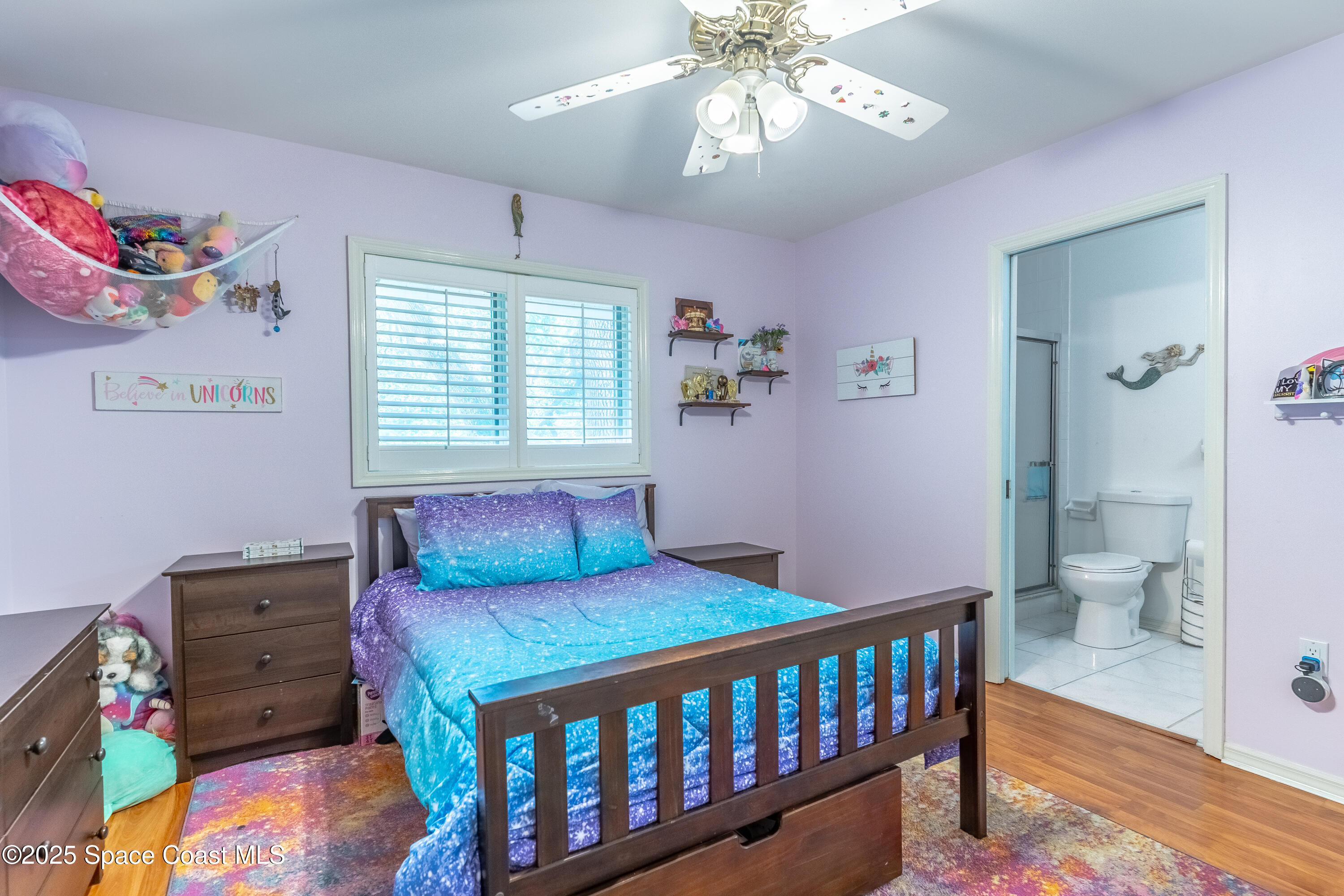 150 Utopia Circle Merritt Island, FL 32952 - Photo 38 of 52 a bedroom with a bed and a chandelier
