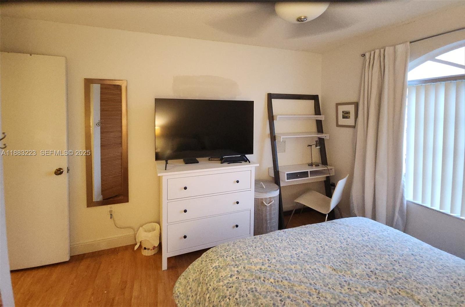 14948 Southwest 38th Terrace Miami, FL 33185 - Photo 3 of 4 a room with a bed and a flat screen tv