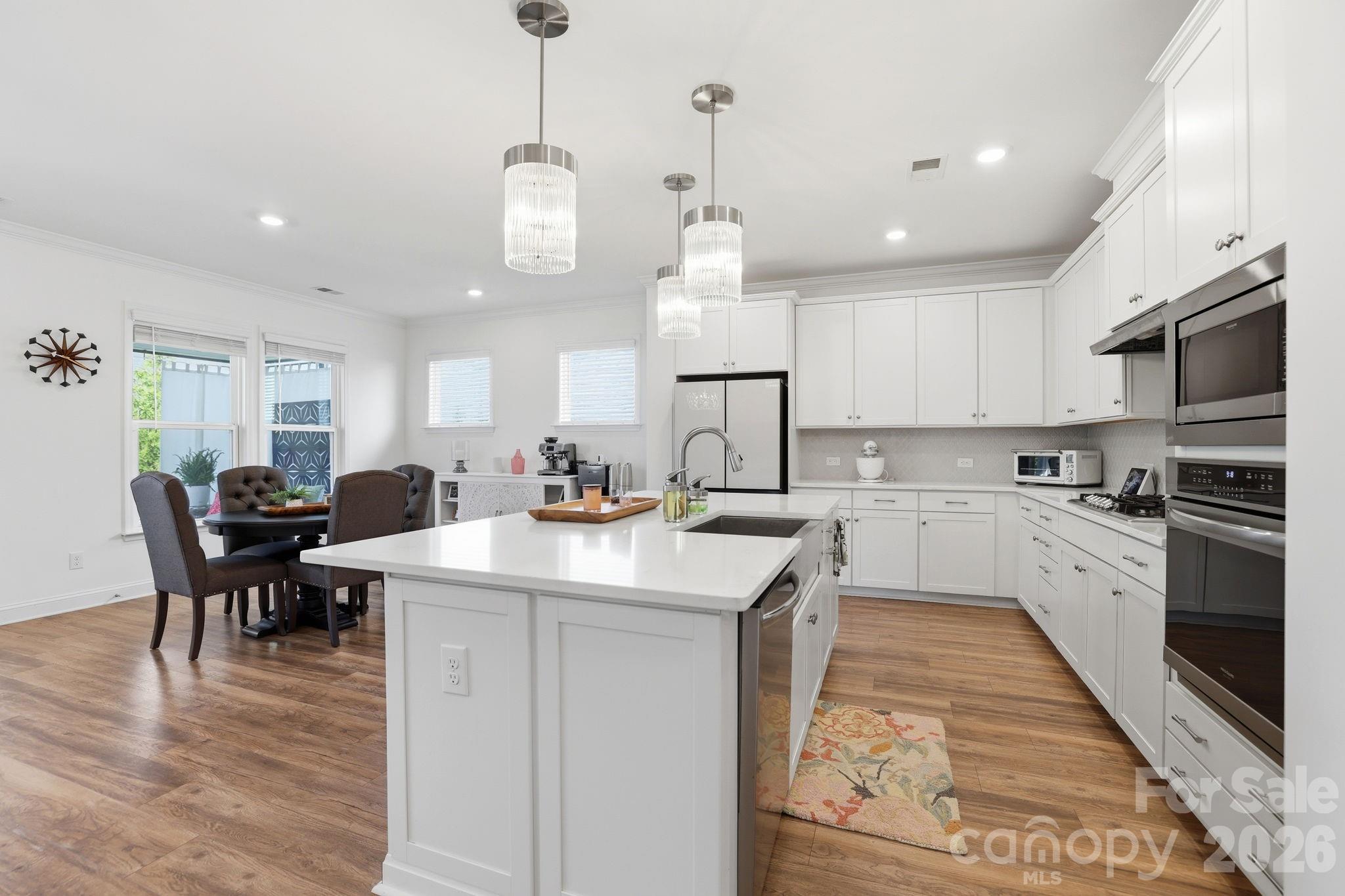 6038 Holland Street Fort Mill, SC 29707 - Photo 9 of 48 a large kitchen with kitchen island a sink a stove a dining table and chairs