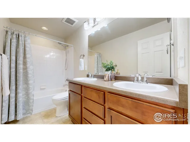 a bathroom with a sink a toilet a mirror and shower