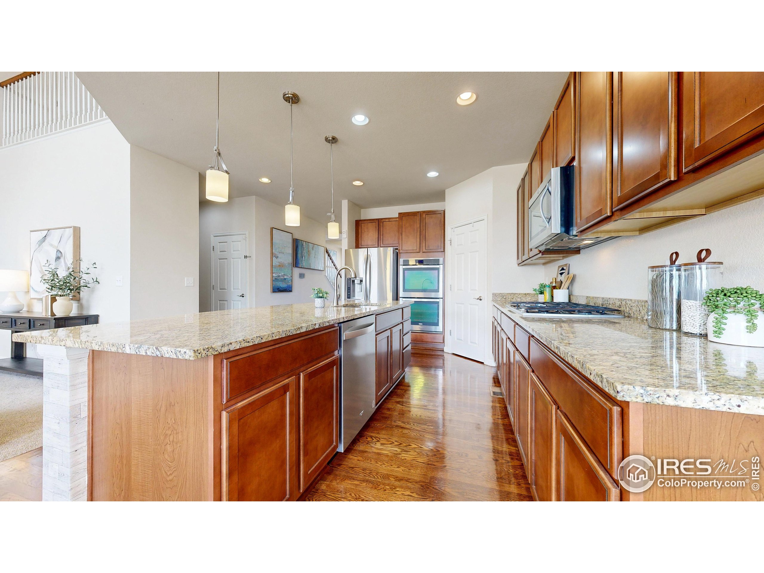 6748 Rainier Road Timnath, CO 80547 - Photo 9 of 34 a kitchen with stainless steel appliances granite countertop a sink stove and cabinets