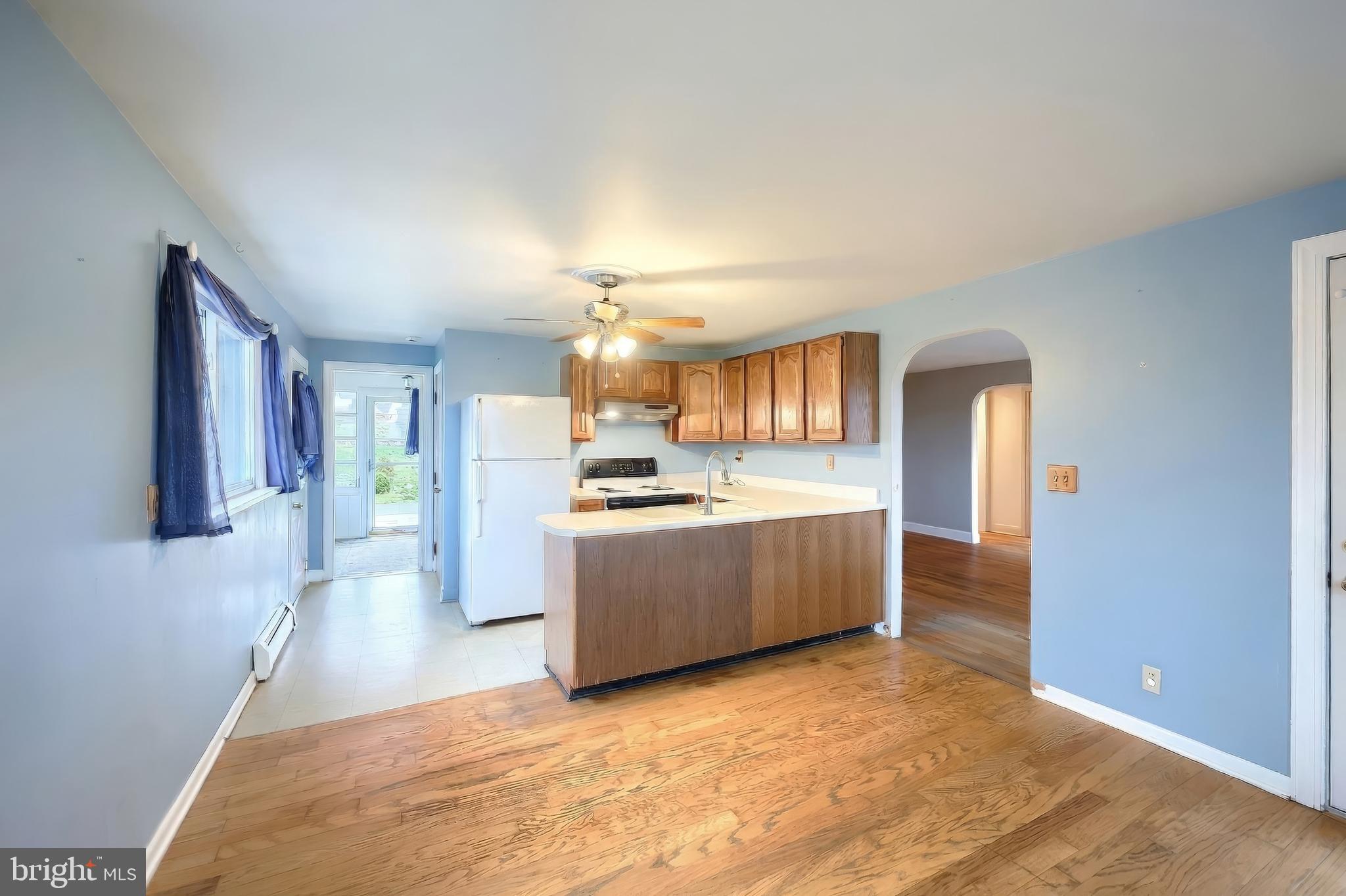 754 Bridgeton Road Fawn Grove, PA 17321 - Photo 24 of 42 a large white kitchen with kitchen island a sink a refrigerator and a stove