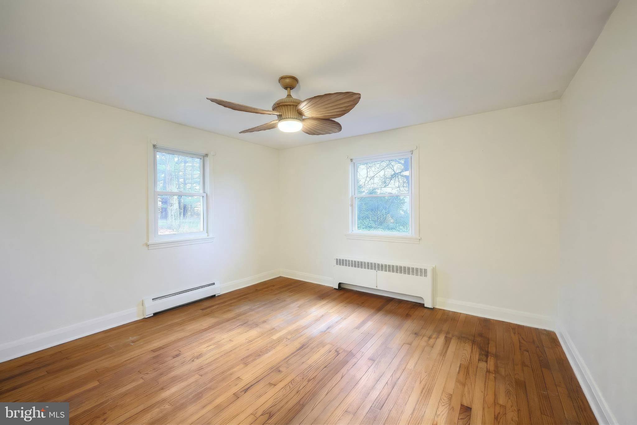 754 Bridgeton Road Fawn Grove, PA 17321 - Photo 29 of 42 an empty room with wooden floor chandelier fan and windows