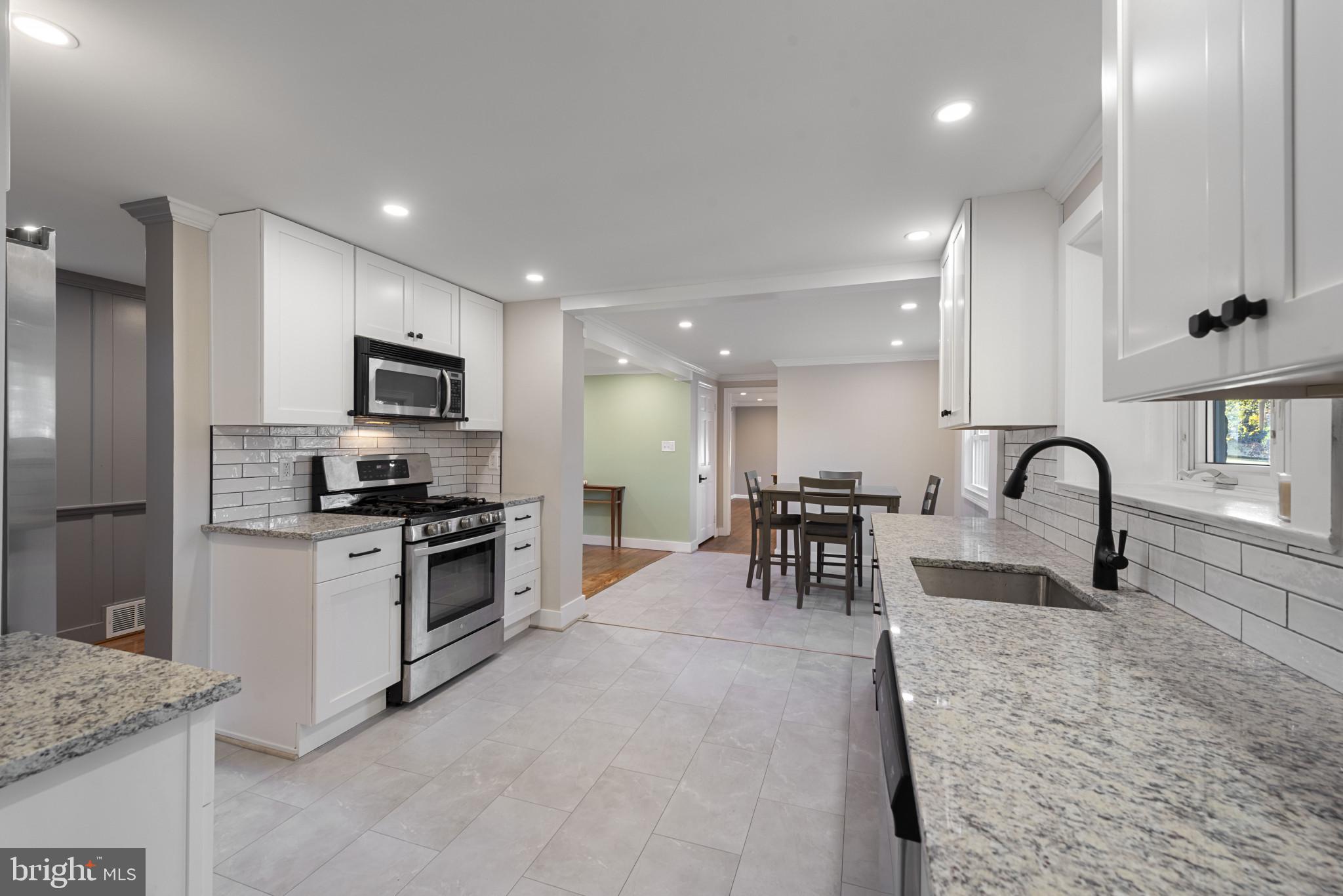 504 Hampton Lane Baltimore, MD 21286 - Photo 8 of 31 a kitchen with stainless steel appliances granite countertop a stove a sink a refrigerator and white cabinets
