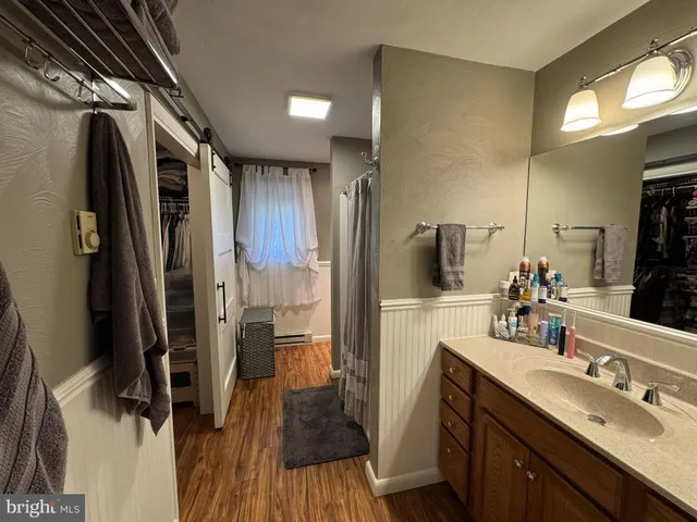 a bathroom with a sink a toilet a mirror and shower