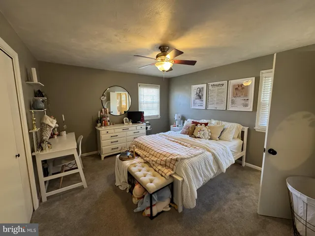 a bedroom with a bed a chandelier and dresser