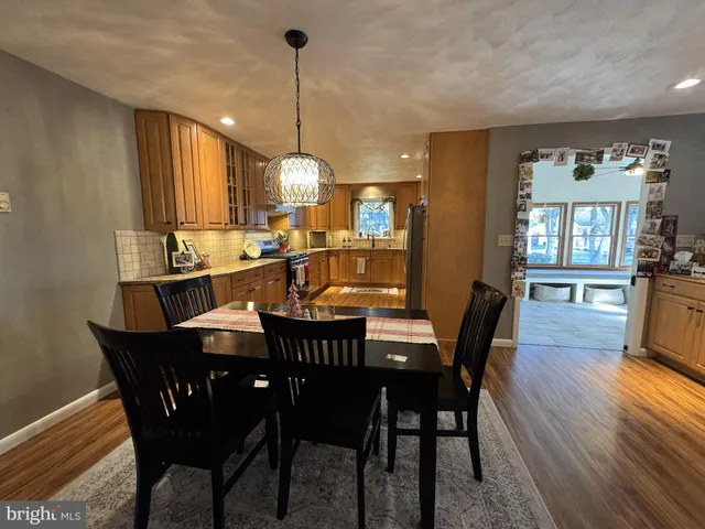 a dining room with furniture a chandelier and wooden floor