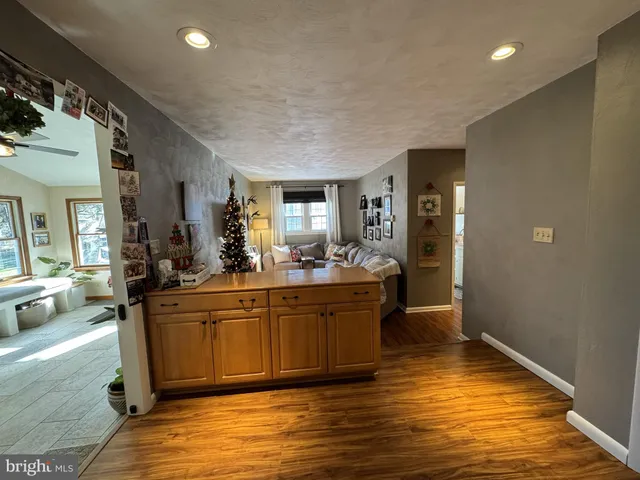 a living room with kitchen island granite countertop wooden floor and a view of living room