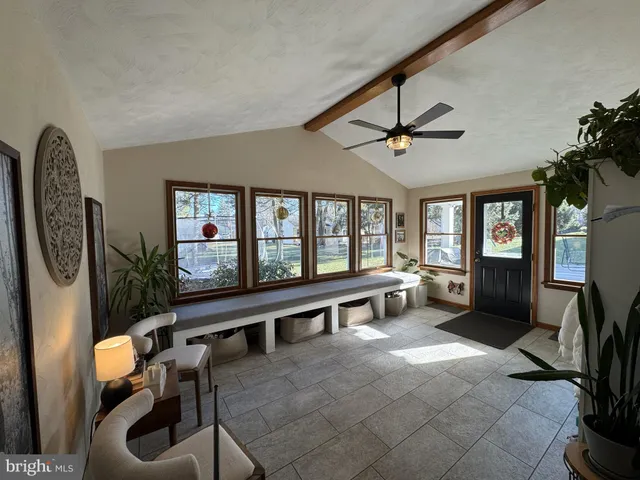 a large living room with furniture a flat screen tv and a large window