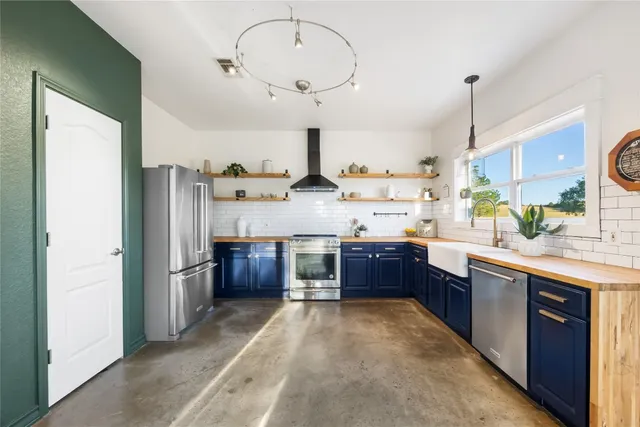 a kitchen with stainless steel appliances kitchen island granite countertop a refrigerator stove and sink