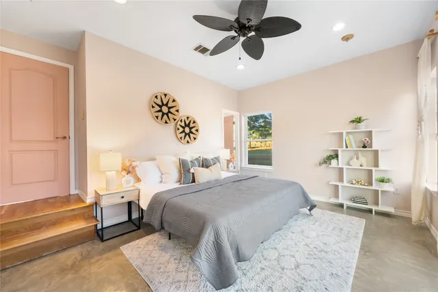 a bedroom with a large bed and a chandelier