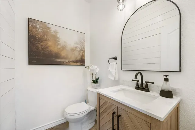 a bathroom with a sink a toilet and a mirror
