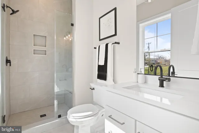 a spacious bathroom with a double vanity sink a toilet and shower