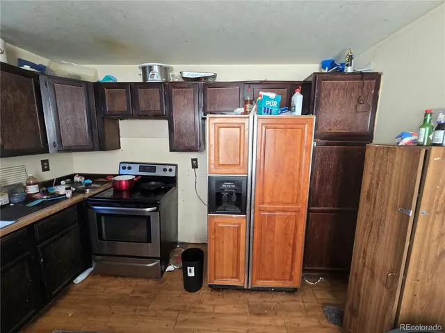 a kitchen with stainless steel appliances granite countertop a refrigerator and a stove top oven
