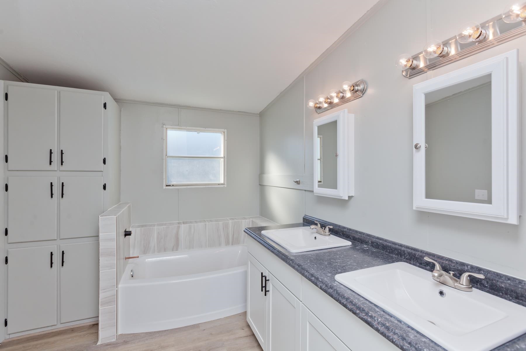 3066 Cardinal Court Grand Junction, CO 81504 - Photo 22 of 41 a bathroom with a sink double vanity granite tub and a mirror