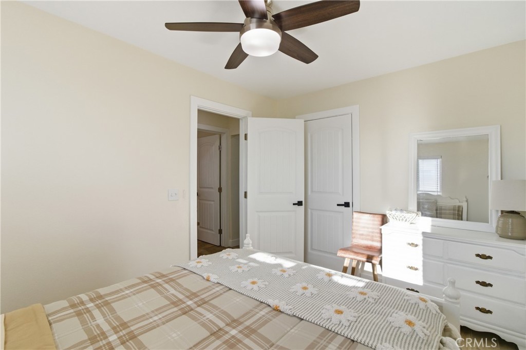 3552 Condalia Avenue Yucca Valley, CA 92284 - Photo 15 of 30 a bedroom with a bed and a chandelier fan