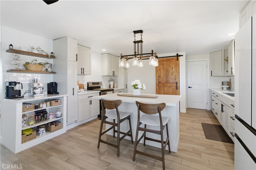 3552 Condalia Avenue Yucca Valley, CA 92284 - Photo 8 of 30 a kitchen with stainless steel appliances a table and chairs in it