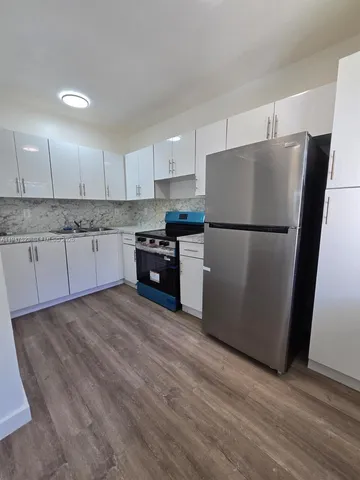 a kitchen with a refrigerator a stove top oven a sink and dishwasher
