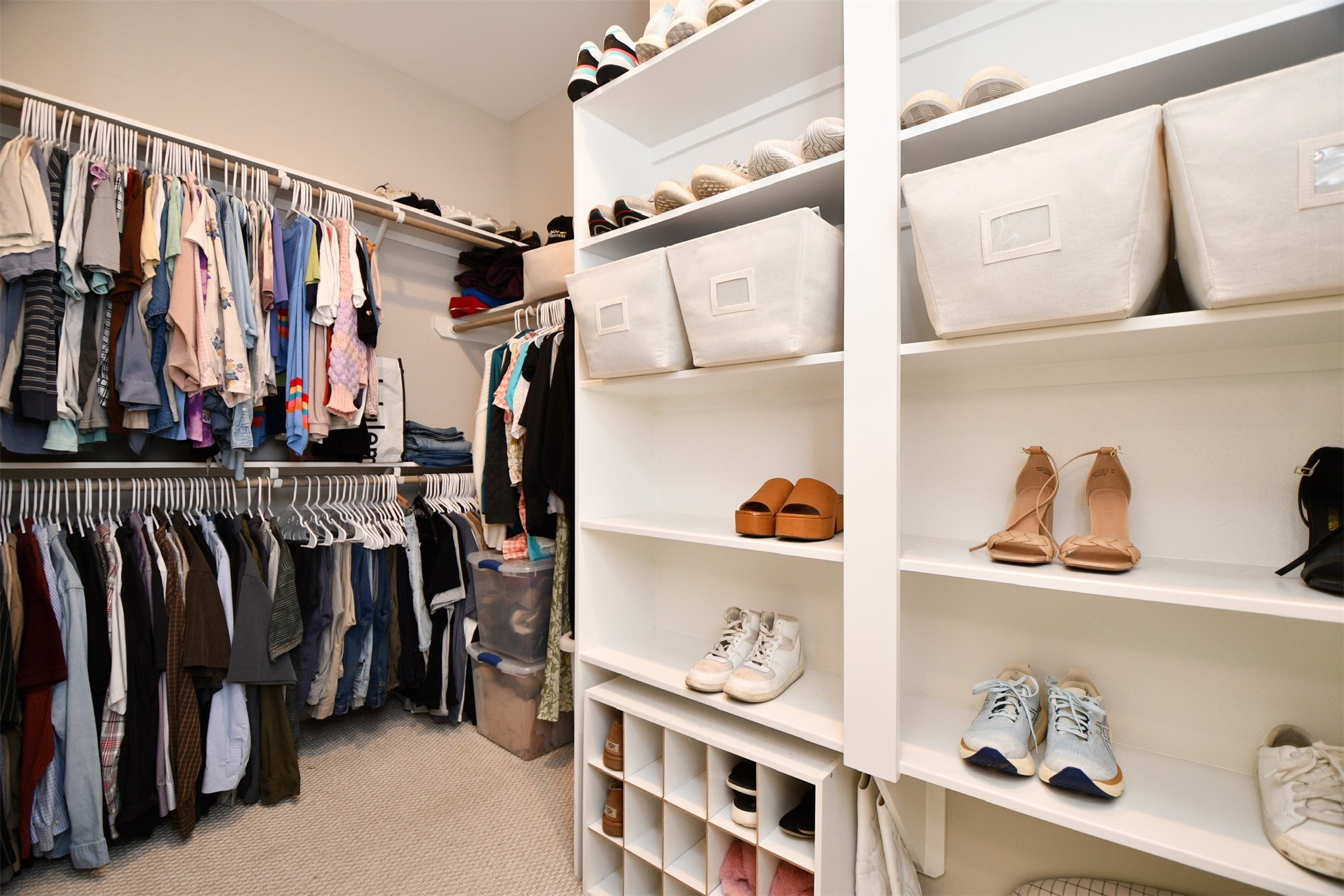 1239 West Tidwell Road Houston, TX 77091 - Photo 20 of 35 This photo showcases a spacious, well-organized walk-in closet featuring ample hanging space, shelving for shoes, and storage bins, creating a tidy and functional environment.