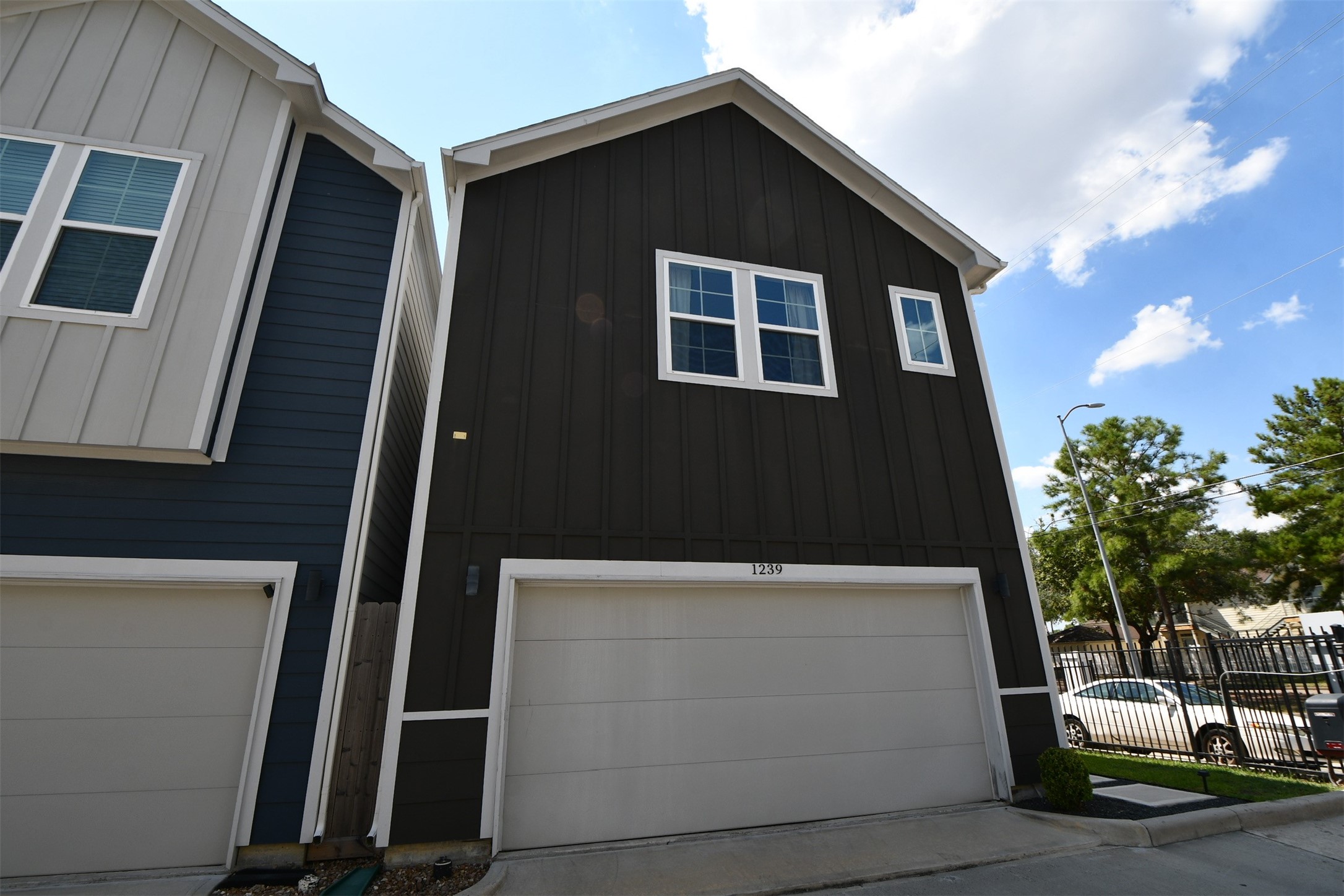 1239 West Tidwell Road Houston, TX 77091 - Photo 2 of 35 Modern townhome with a two-car garage, featuring a sleek exterior. Located in a well-maintained neighborhood, it offers easy access to nearby amenities.