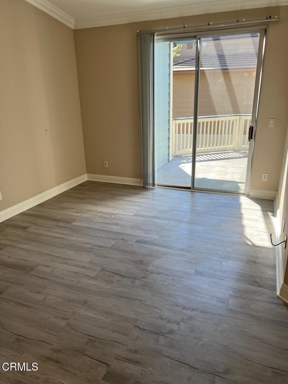2394 Pleasant Way, Unit J Thousand Oaks, CA 91362 - Photo 7 of 12 a view of an empty room with wooden floor and a window
