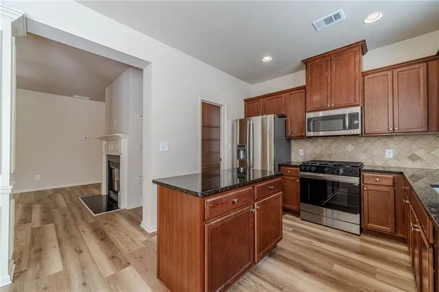 a kitchen with granite countertop cabinets stainless steel appliances and a sink