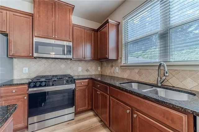 a kitchen with granite countertop a refrigerator and a sink