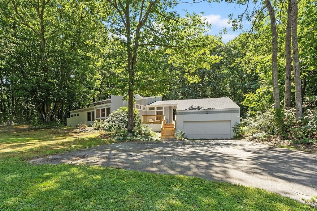 56 Old Littleton Road Harvard, MA 01451 - Photo 2 of 26 a view of a house with a big yard and large trees