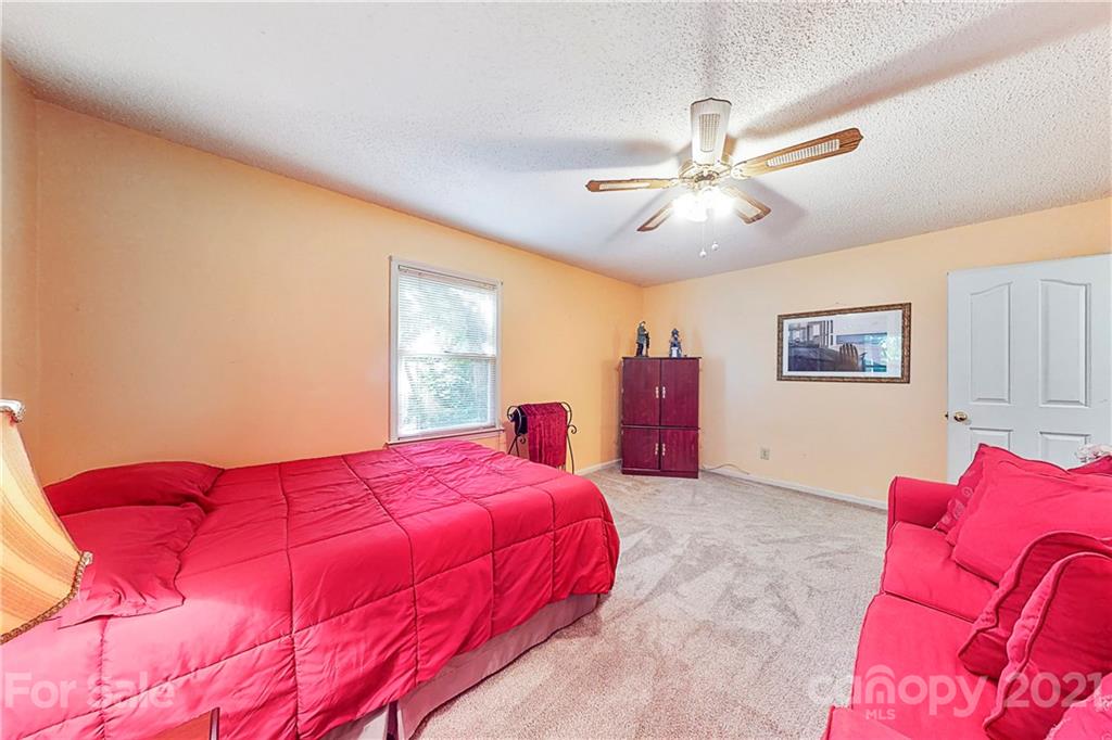 27036 Fahleh Cove Tega Cay, SC 29708 - Photo 18 of 21 a bedroom with a large bed and a chandelier