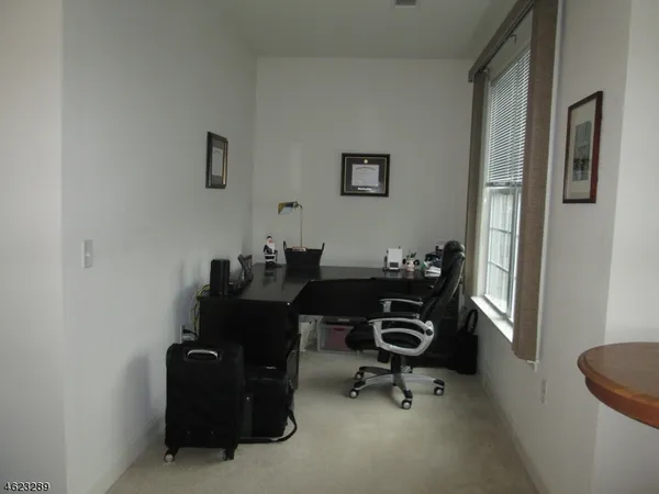 a view of a workspace with furniture and a window