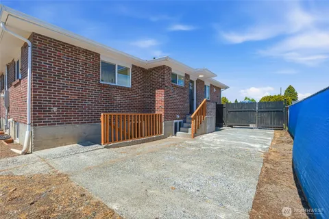 a view of a house with a small yard and wooden fence