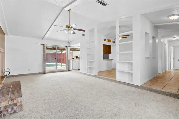 en empty room with windows and ceiling fan