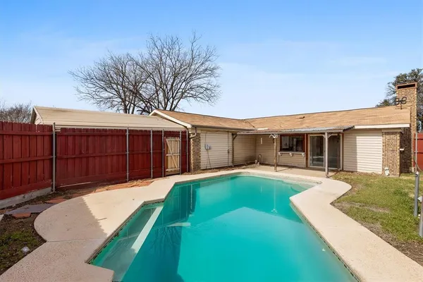 a front view of a house with yard patio and wooden fence