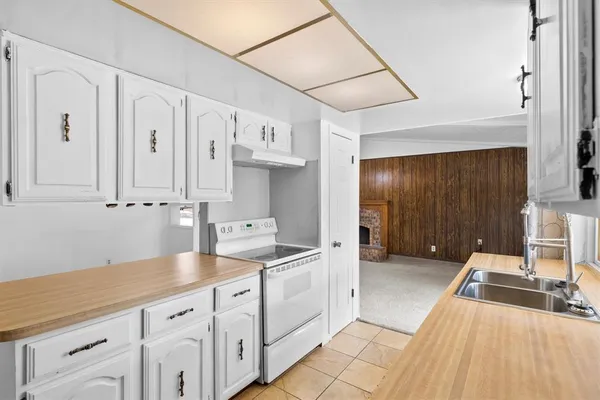 a kitchen with granite countertop white cabinets and white appliances