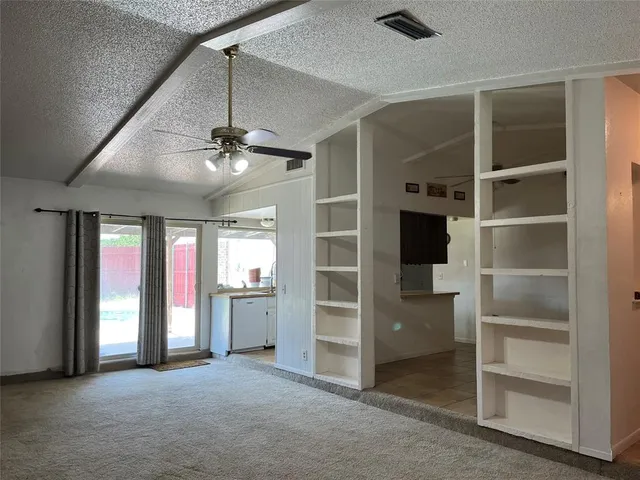 a view of an empty room with a fireplace and a window