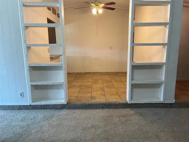 an empty room with cabinet and windows