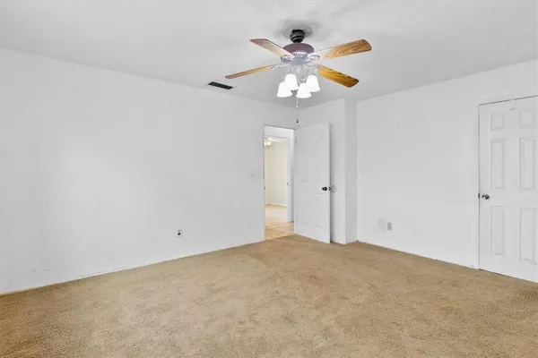 an empty room with a window and a ceiling fan