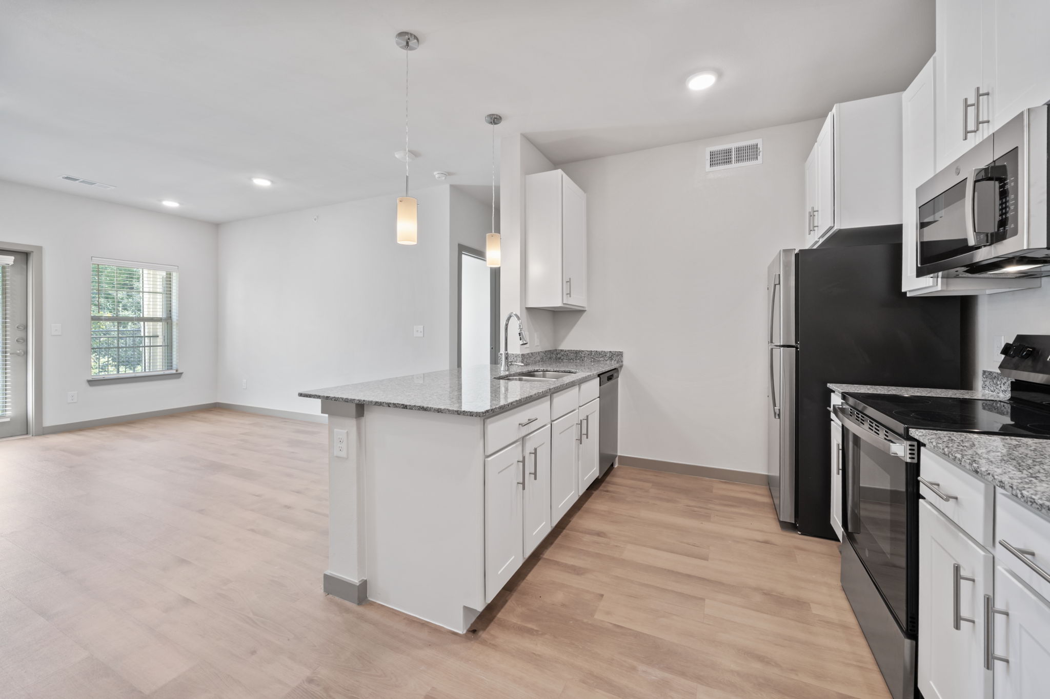 a kitchen with stainless steel appliances granite countertop a refrigerator a stove and a sink