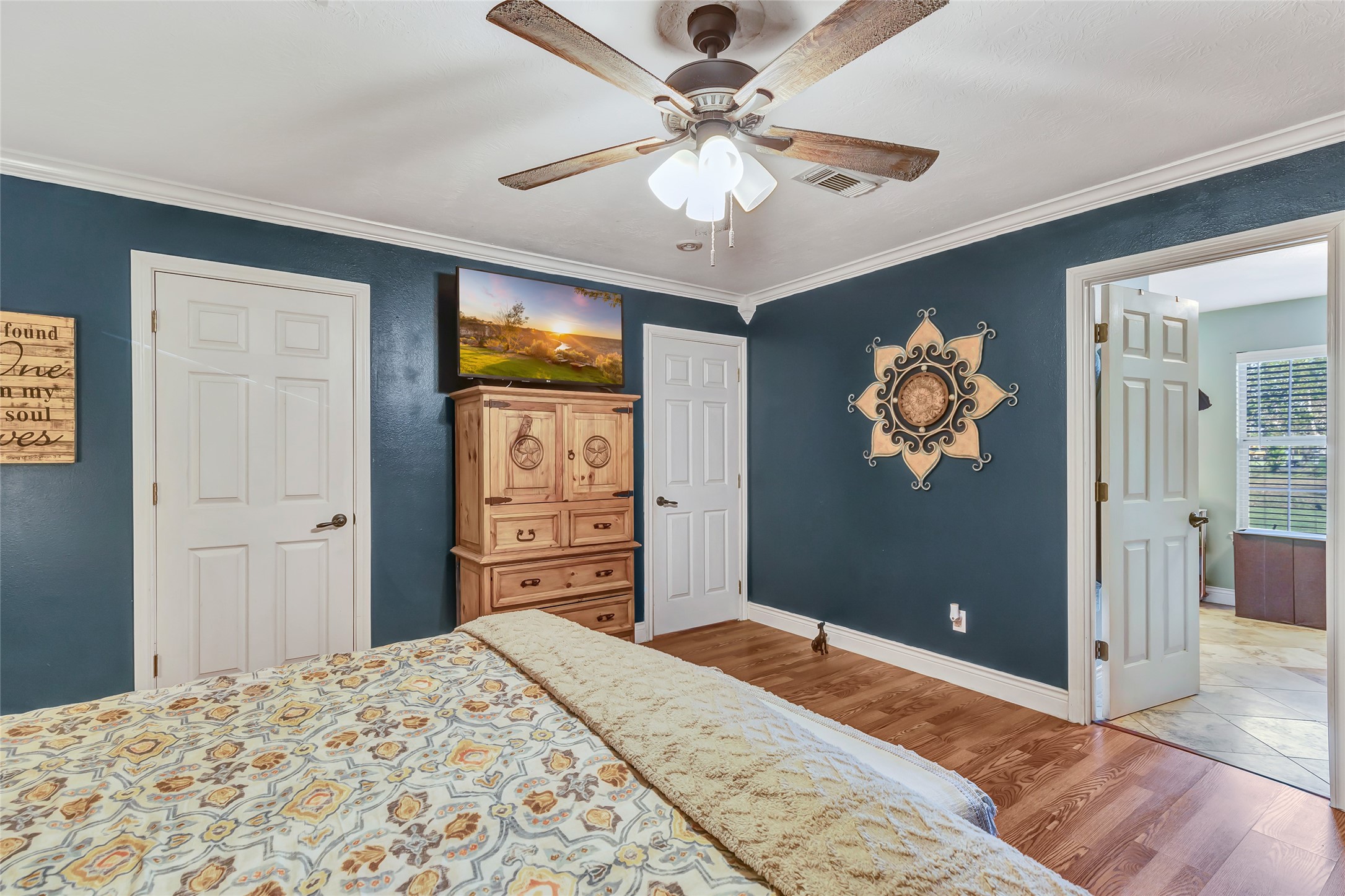 97 County Road 2268 Cleveland, TX 77327 - Photo 17 of 36 a bedroom with a bed and a chandelier