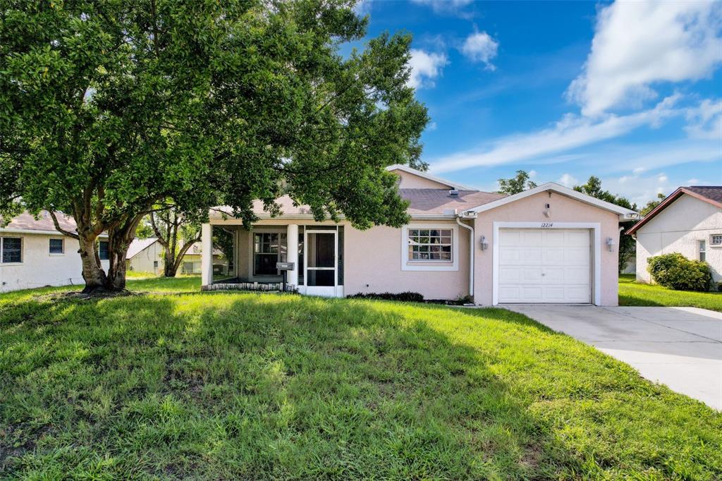 a front view of a house with a yard and trees