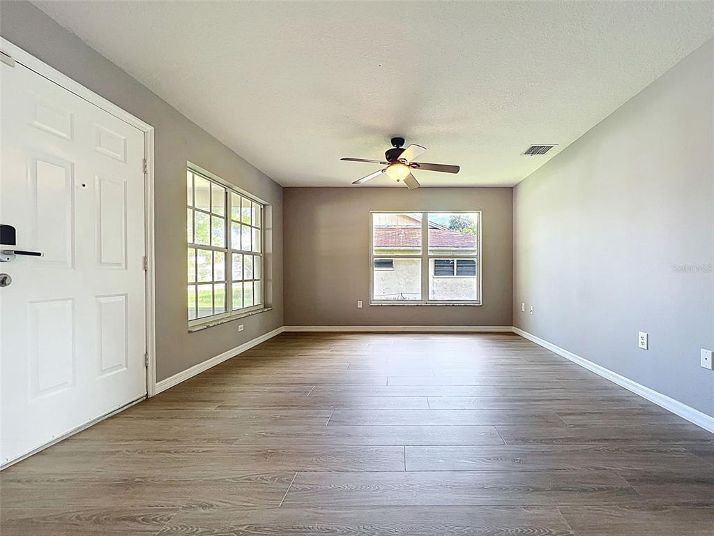 12214 Partridge Hill Row Hudson, FL 34667 - Photo 13 of 80 a view of an empty room with a window and wooden floor