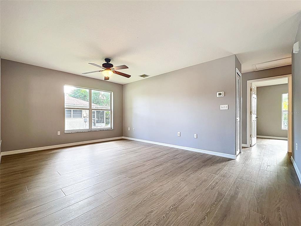 12214 Partridge Hill Row Hudson, FL 34667 - Photo 16 of 80 a view of an empty room with wooden floor and a window