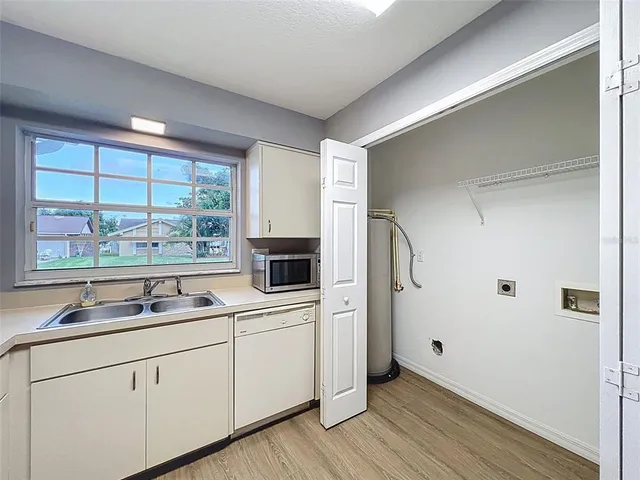 an empty room with wooden floor ceiling fan and windows