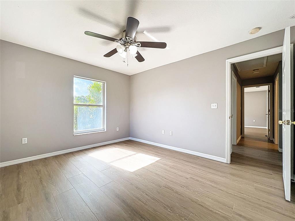 12214 Partridge Hill Row Hudson, FL 34667 - Photo 33 of 80 an empty room with wooden floor fan and windows