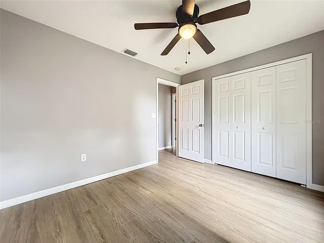 a backyard of a house with plants and large tree