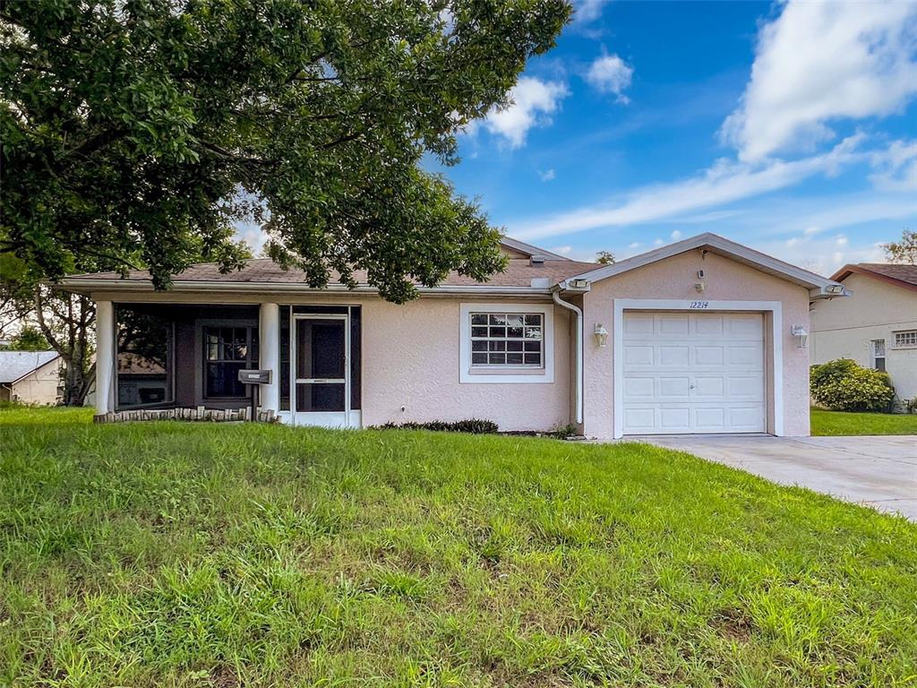 12214 Partridge Hill Row Hudson, FL 34667 - Photo 78 of 80 front view of a house with a yard