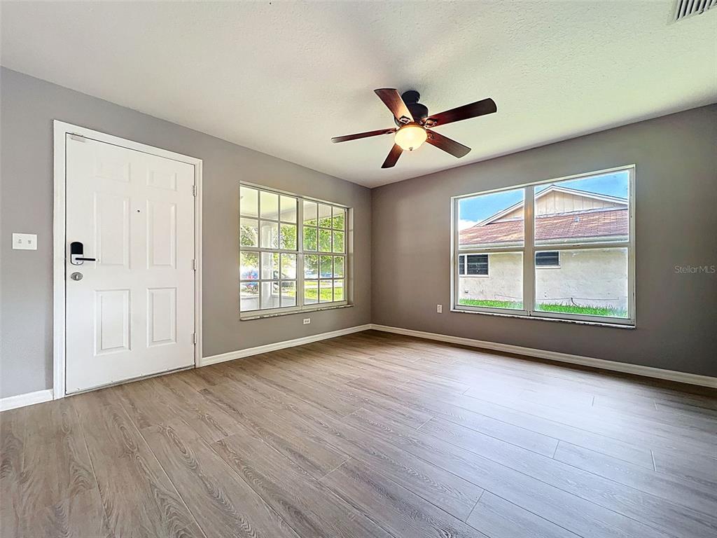 12214 Partridge Hill Row Hudson, FL 34667 - Photo 10 of 80 a view of an empty room with wooden floor and a window