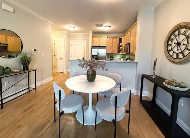 a view of a a dining room with furniture window and wooden floor