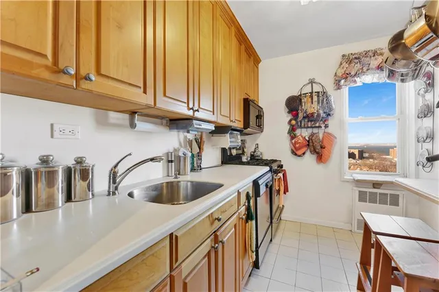 a kitchen with stainless steel appliances granite countertop a sink and a refrigerator