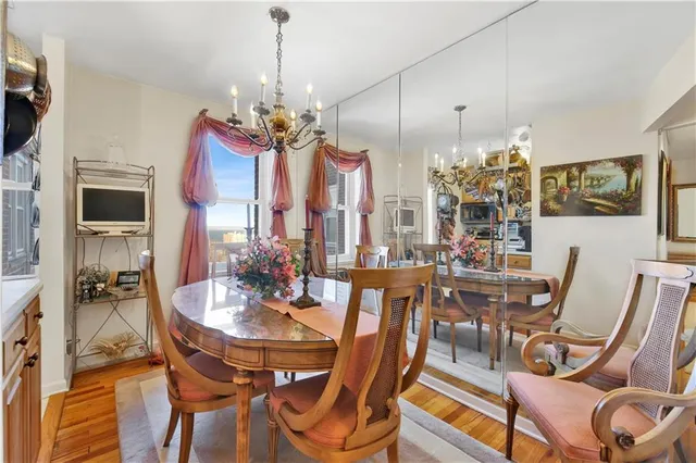 a view of a dining room with furniture a chandelier and wooden floor